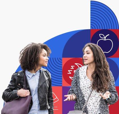 Two young women walk and talk together.