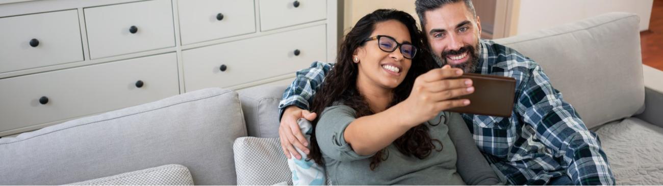 A couple smile while taking a photo